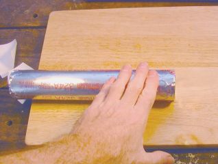 Roll end on flat surface to round it out